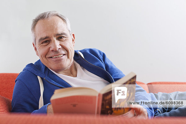 Senior man reading book  smiling  portrait
