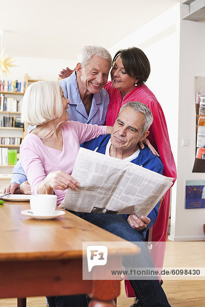Senior men and women reading newspaper