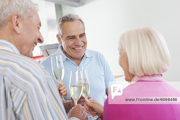Senior men and women drinking sparkling wine  smiling