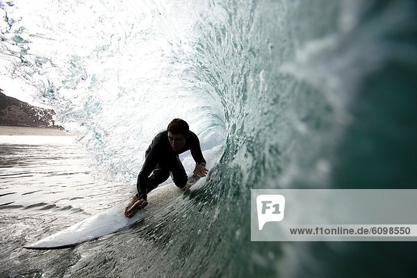A male surfer navigates the barrel while surfing at Westward in Malibu  California.