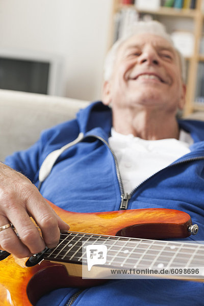 Senior Mann Zupfgitarre  lächelnd
