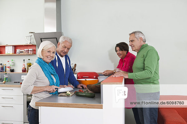 Seniorinnen und Senioren beim Kochen von Speisen