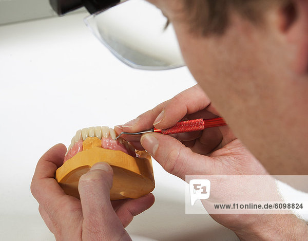 Zahnarzt auf der Suche nach Zahnersatz im Dentallabor