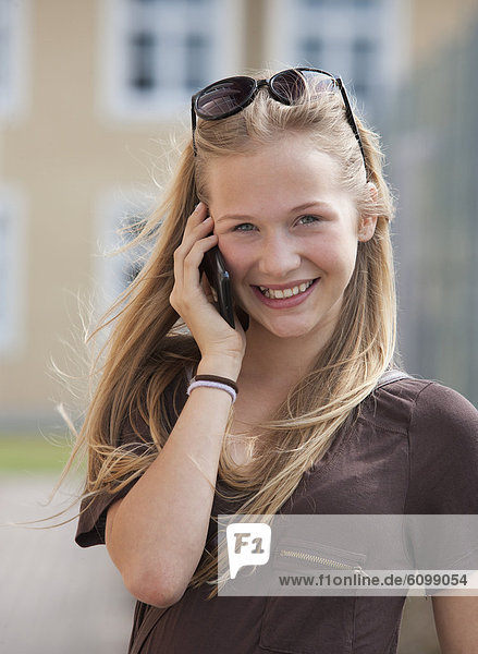 Austria  Teenage girl on mobile phone  smiling  portrait