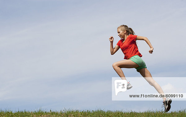 Austria  Teenage girl running on grass