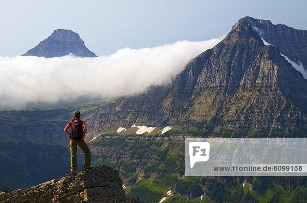 A female hiker takes in the view on the Highline Trail in Glacier National Park  Montana.