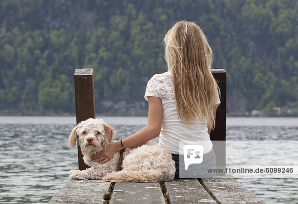 Austria  Teenage girl with dog on jetty