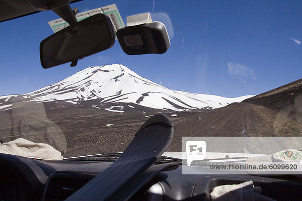 Volcan Lonquimay in Chile seen through the windshield of a car