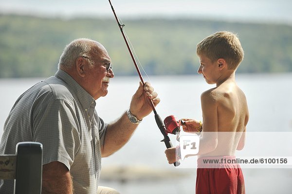 Maine Camp Life: A man talks fishing with a young boy on Crystal Lake near Harrison  Maine