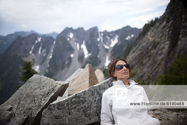 A woman takes a break after hiking to Kendall Katwalk on the Pacific Crest Trail in the Cascade Mountains near Snoqualmie Pass in Kittatas County  Washington State