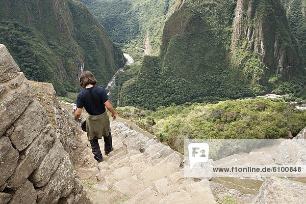 A young man checks out the scenery and ruins of Machu Picchu.