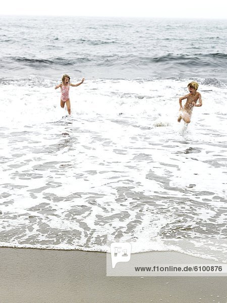 brother and sister play in maine ocean