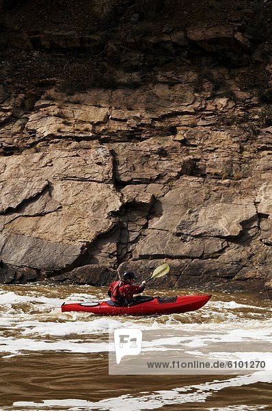A middle age man paddles his whitewater kayak down the Salt River in Arizona.