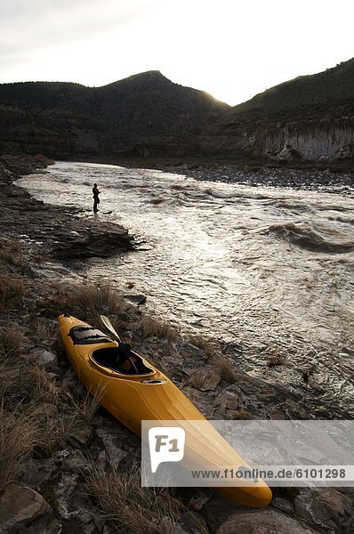 A whitewater kayak rests on the shore after a surf session in Ledge Rapid on the Salt River  AZ.