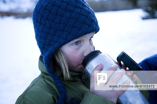 A boy enjoys a cup of hot chocolate in the California backcountry.