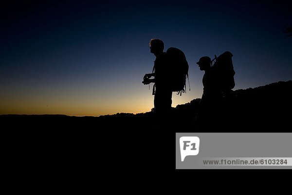 Two backpackers watch the sunset at Castle Rock State Park  California. Silhouette.
