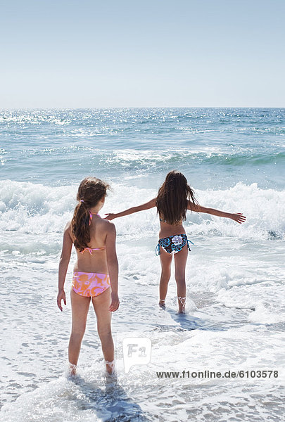 Two young girls playing in the waves at Torrance Beach in Los Angeles  California.