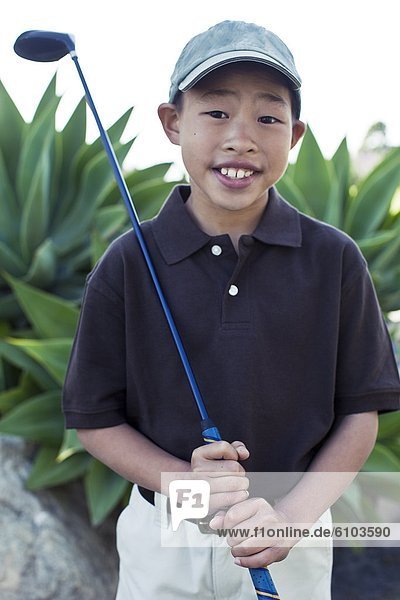 A portrait of a young boy with his golf club at a golf club in Los Angeles  California