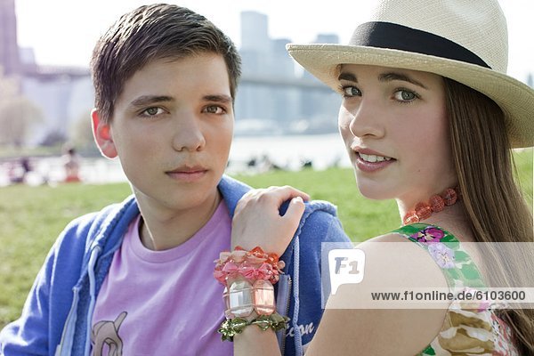 A young couple posing for a portrait in the Brooklyn Bridge Park in Brooklyn  New York.
