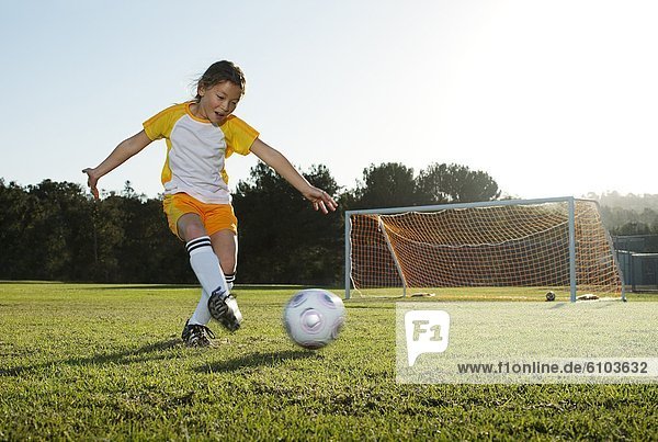 A young girl playing soccer on a soccer field in Los Angeles  California.