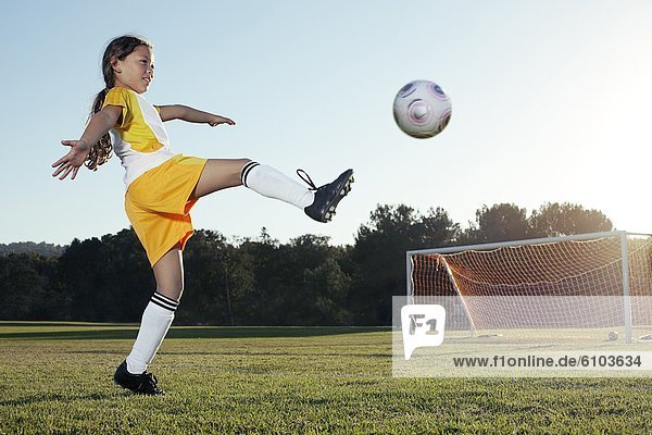 A young girl playing soccer on a soccer field in Los Angeles  California.