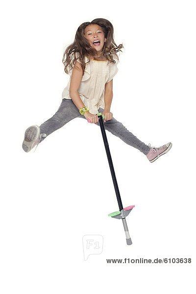 A young girl jumping on a pogo stick.