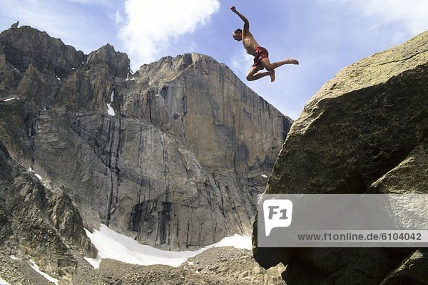 Man jumping off rock below Long's Peak  Rocky Mountain National Park  Estes Park  Colorado.