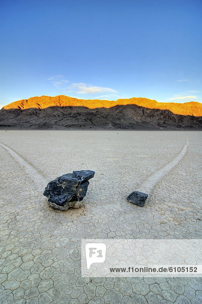 Two rocks leave trails of their movement on The Racetrack in Death Valley National Park at sunrise  California.