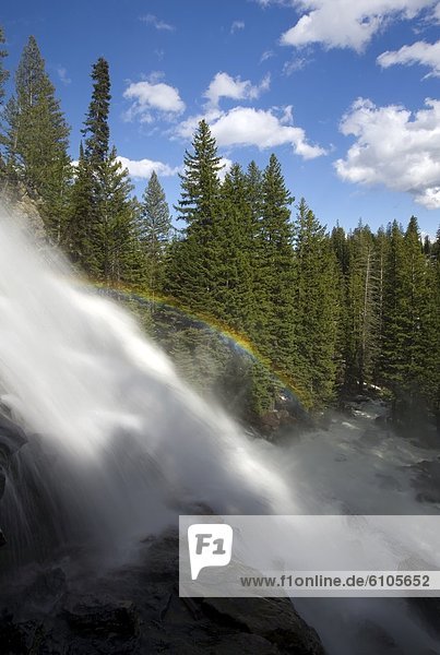 A rainbow is created by the mist coming from Hidden Falls in Grand Teton National Park  Wyoming.