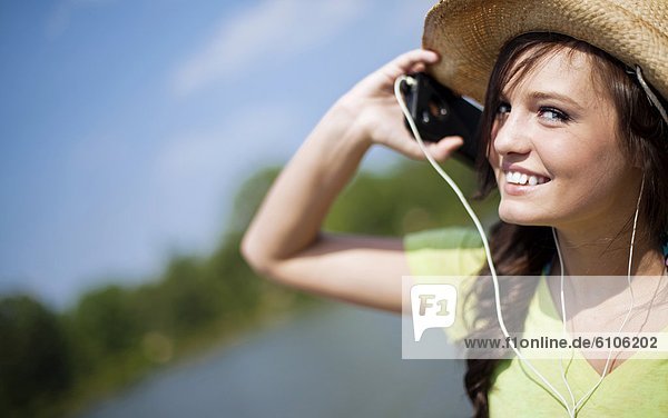Frau  zuhören  sehen  lächeln  Musik  Blick in die Kamera  jung