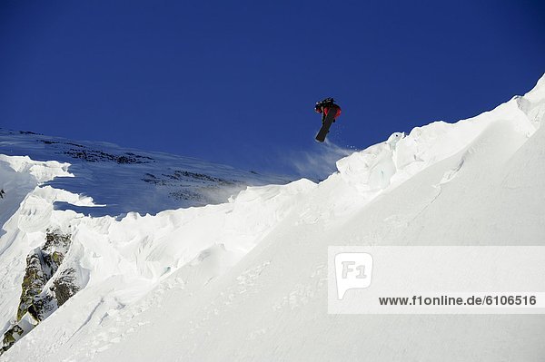 A snowboarder catches air off a cornice in the Lake Tahoe backcountry  California.