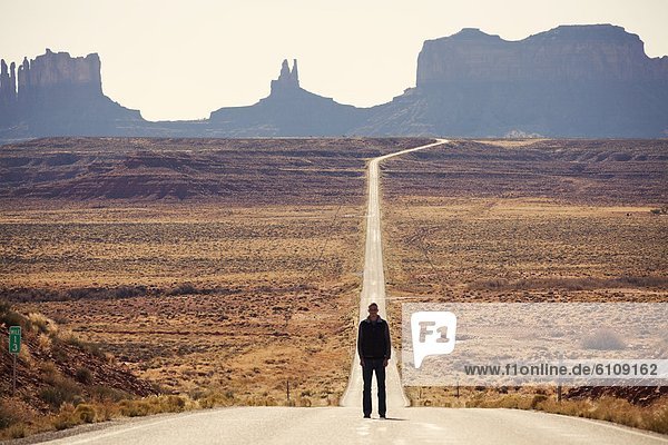A traveler pauses for a picture in Monument Valley