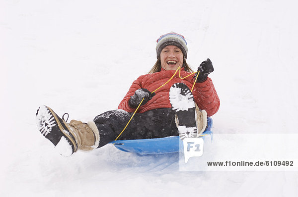 A woman sledding during snowstorm.