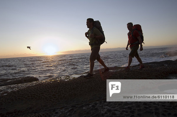 Hikers at waterhole on rocky coast.Evangelos Kotsopoulos and Greg Dearden hiking along the Pacific Ocean coast on a rocky headla