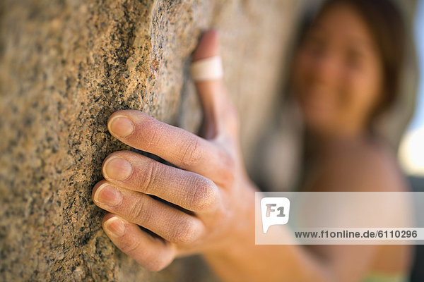 A female climber's hand on rock.