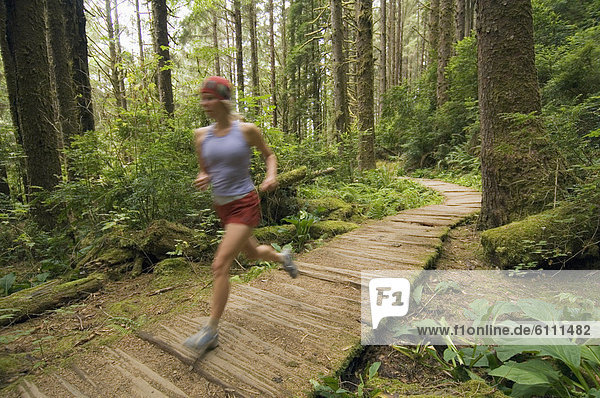 Runner on boardwalk in forest.