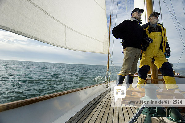 Men on the deck of a sailing yacht.