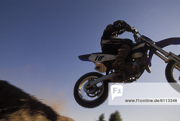 Motor-cross bike jumping in air.