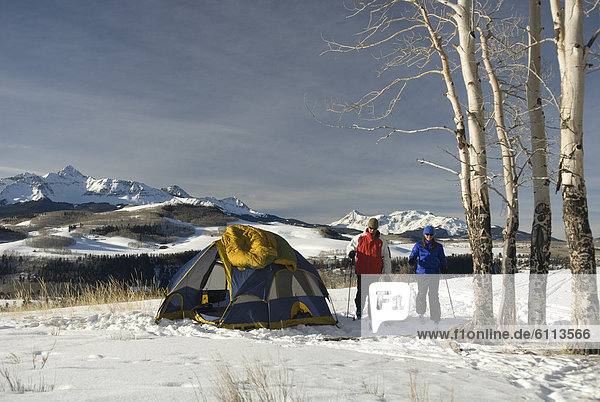 Man and woman camping in snow.