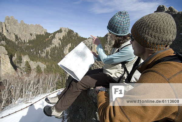 Man and Woman reading map on rock.
