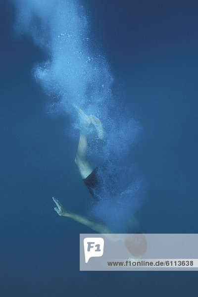 Man diving and swimming in ocean.