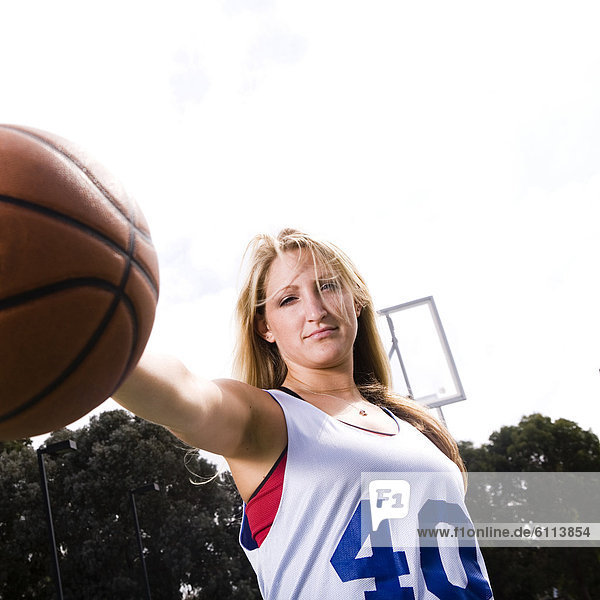An athletic woman plays basketball.