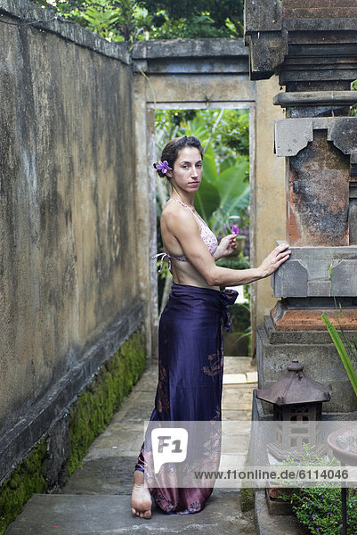 A young woman standing in the grounds of a resort in Bali  Indonesia.