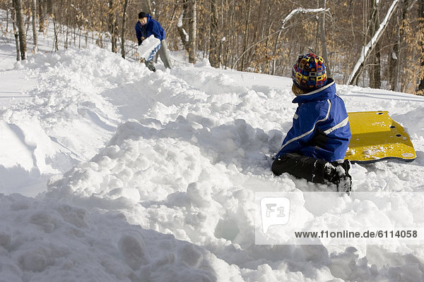 Girl sledding with her father  Newry  Maine.