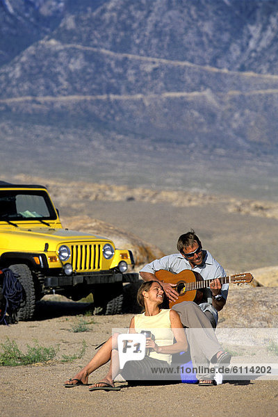 sitzend  Frau  Mann  Wüste  Gitarre  Geländewagen  spielen