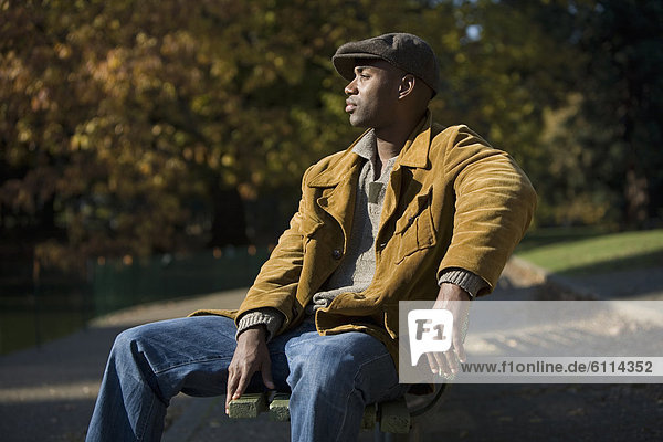 Man of African ethnicity sits on park bench in Portland  Oregon.