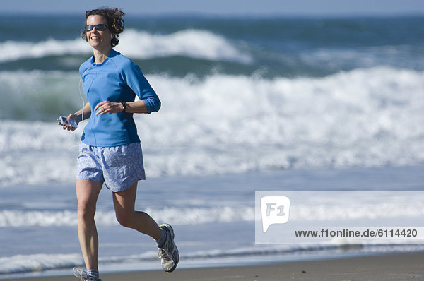 Woman running on beach  Oregon.