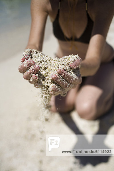 A woman holds a handful of sand in Loreto  Baja California Sur  Mexico.