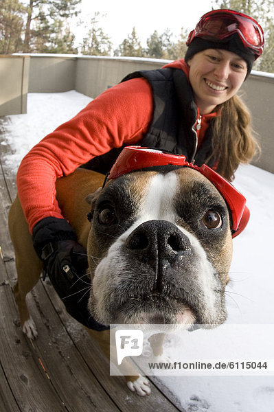hoch  oben  nahe  Frau  Schutzbrille  Hund  jung  Kleidung  Schnee