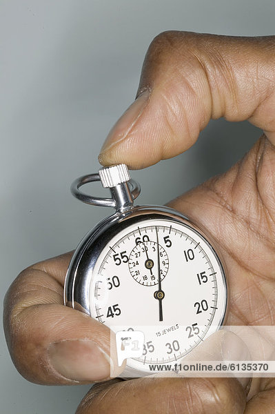 Close up of hand holding stop watch